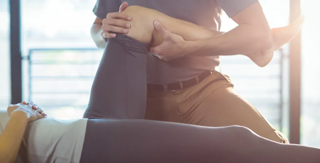 Physiotherapist stretching a patient's leg